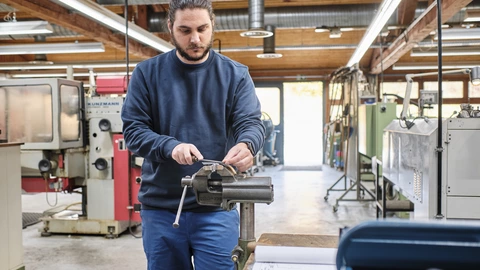 Auszubildender arbeitet an einem Schraubstock