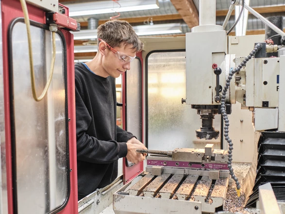Auszubildender arbeitet an einer Maschine