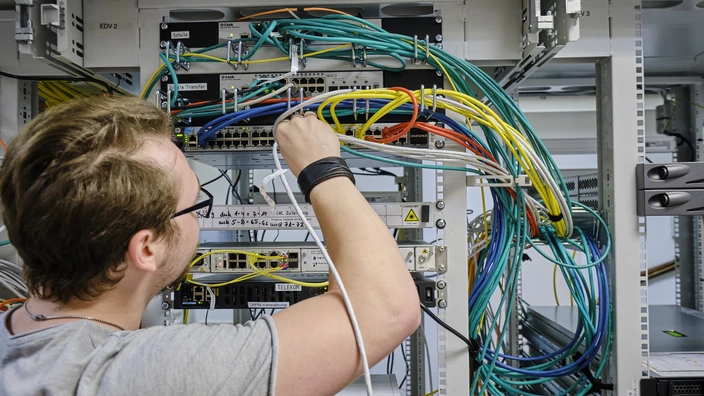 Auszubildender arbeitet an einer Verkabelung in der Ausbildung Fachinformatik im BBW Offenburg