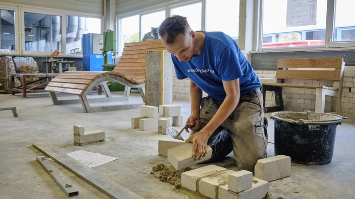 Auszubildender ist am Mauern von Steinen im Ausbildungsgang Bautechnik im BBW Offenburg