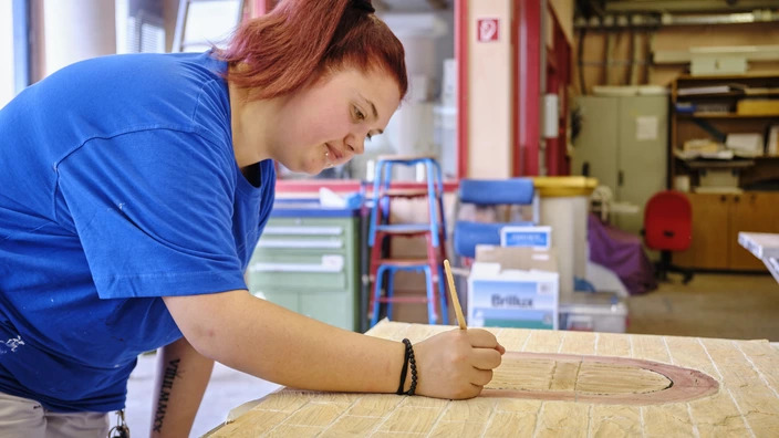 Auszubildende arbeitet in der Werkstatt für Malerinnen und Maler im BBW Offenburg